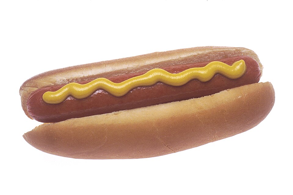 A grilled hot dog with a stripe of yellow mustard