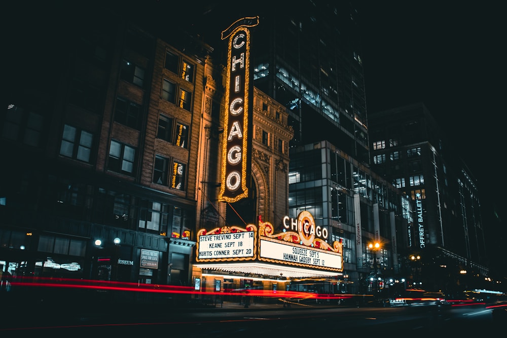 A historic theater marquee lit up over a city street at night